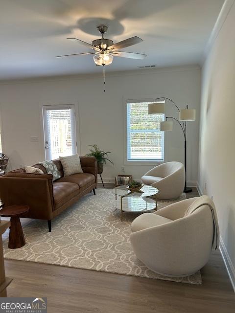 322 Heron St, Ball Ground, GA 30107 - living area featuring wood finished floors, ceiling fan, and ornamental molding