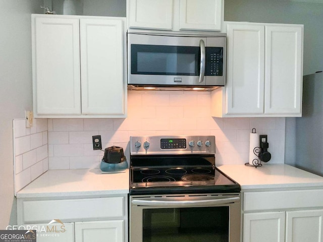 5553 Strathmoor Manor Cir, Lithonia, GA 30058 - kitchen with stainless steel appliances, white cabinets, and light countertops