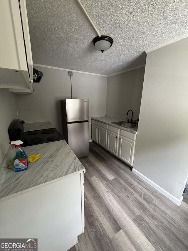 1040 Chestney St, Macon, GA 31217 - kitchen featuring freestanding refrigerator, electric range, crown molding, a textured ceiling, and wood finished floors