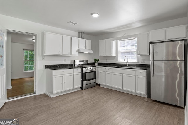 5861 Community Rd SE, Mableton, GA 30126 - kitchen with appliances with stainless steel finishes, under cabinet range hood, white cabinets, and dark countertops