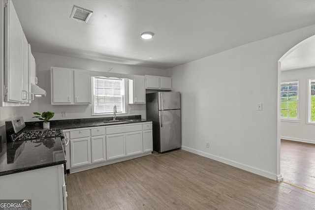 5861 Community Rd SE, Mableton, GA 30126 - kitchen with appliances with stainless steel finishes, arched walkways, plenty of natural light, and white cabinetry