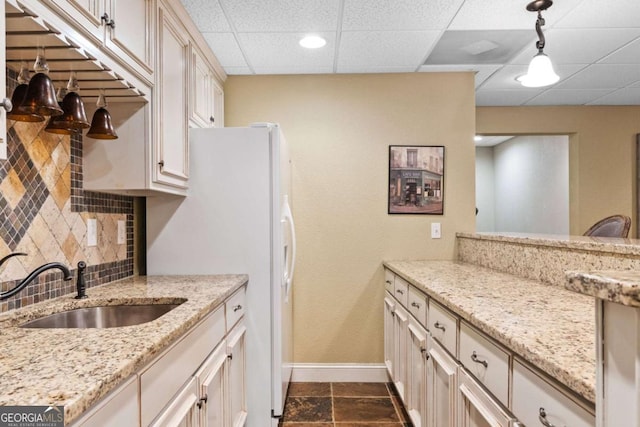 2118 Chatham, Dalton, GA 30720 - kitchen with tasteful backsplash, light stone countertops, a paneled ceiling, hanging light fixtures, and dark stone finish floors