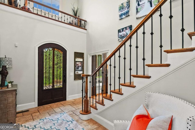 2118 Chatham, Dalton, GA 30720 - entrance foyer featuring a high ceiling, stone tile flooring, arched walkways, and stairs
