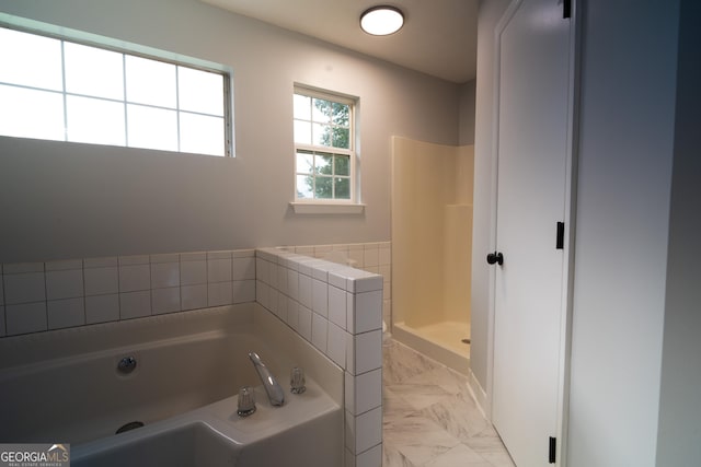 2333 Wilkins Cv, Decatur, GA 30035 - bathroom with marble look tile flooring, a garden tub, and a shower