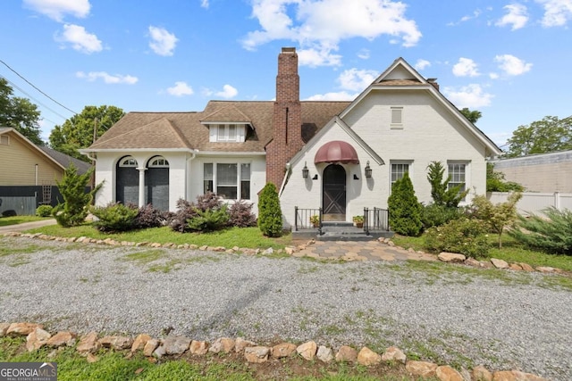 204 S Jefferson Ave, Eatonton, GA 31024 - tudor-style house with a chimney, brick siding, and roof with shingles