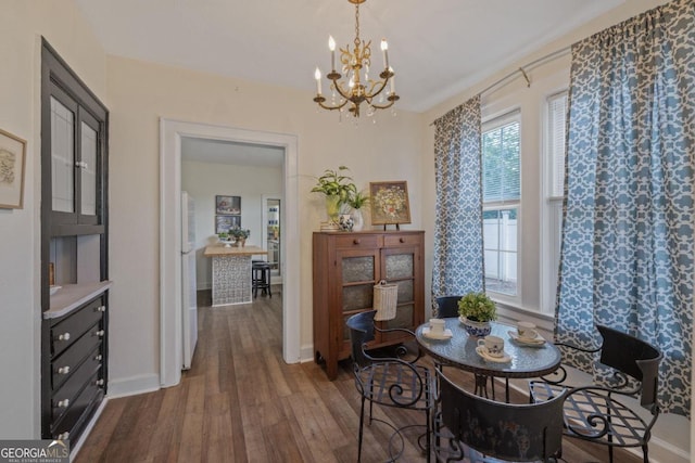 204 S Jefferson Ave, Eatonton, GA 31024 - dining room with dark wood-type flooring and a chandelier