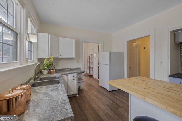 204 S Jefferson Ave, Eatonton, GA 31024 - kitchen featuring freestanding refrigerator, white cabinets, dark wood-style floors, and butcher block countertops