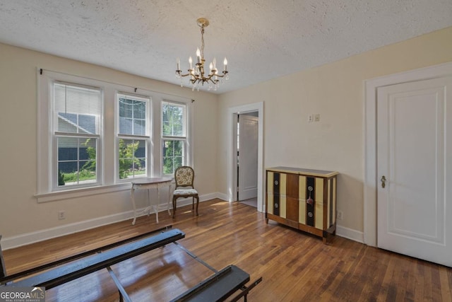 204 S Jefferson Ave, Eatonton, GA 31024 - living area featuring a textured ceiling, a chandelier, and wood finished floors