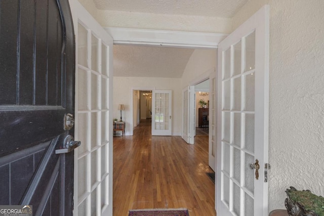 204 S Jefferson Ave, Eatonton, GA 31024 - foyer featuring french doors, wood finished floors, lofted ceiling, a textured wall, and a textured ceiling