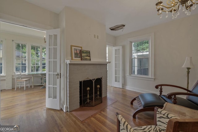 204 S Jefferson Ave, Eatonton, GA 31024 - living room with wood finished floors, a chandelier, and a brick fireplace