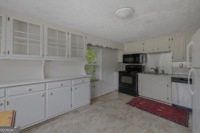 204 S Jefferson Ave, Eatonton, GA 31024 - kitchen featuring black appliances, a textured ceiling, light countertops, glass insert cabinets, and white cabinetry