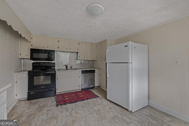204 S Jefferson Ave, Eatonton, GA 31024 - kitchen featuring black appliances, light countertops, cream cabinets, a textured ceiling, and wooden walls