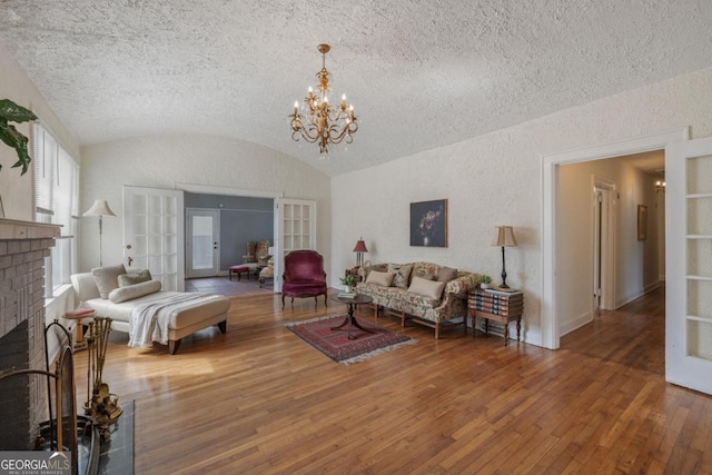 204 S Jefferson Ave, Eatonton, GA 31024 - living area featuring french doors, vaulted ceiling, hardwood / wood-style flooring, a textured ceiling, and a chandelier