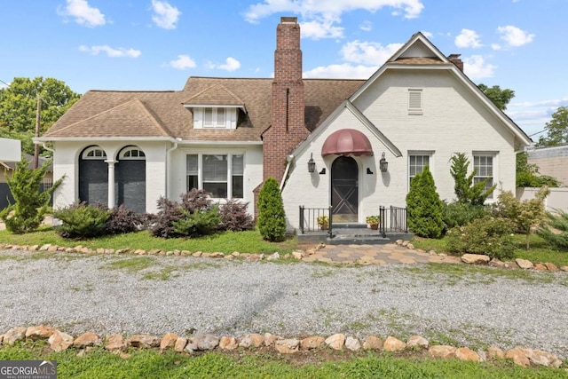 204 S Jefferson Ave, Eatonton, GA 31024 - view of front of house with a chimney, brick siding, and roof with shingles