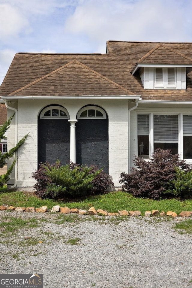 204 S Jefferson Ave, Eatonton, GA 31024 - view of home's exterior featuring a shingled roof and brick siding
