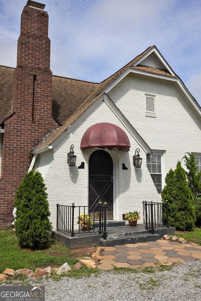 204 S Jefferson Ave, Eatonton, GA 31024 - doorway to property with a chimney, brick siding, and a shingled roof