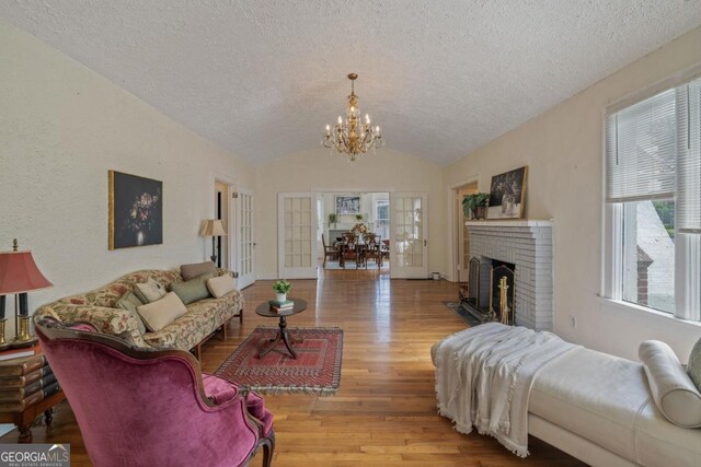 204 S Jefferson Ave, Eatonton, GA 31024 - living area with vaulted ceiling, a chandelier, a textured ceiling, wood finished floors, and healthy amount of natural light
