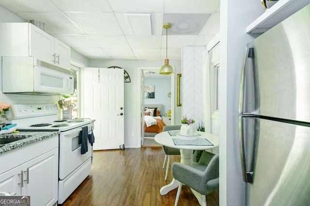 3024 Saddle Creek Dr, Gainesville, GA 30507 - kitchen featuring white appliances, a drop ceiling, white cabinetry, dark wood finished floors, and pendant lighting