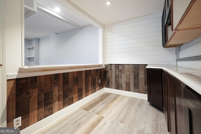 174 Village Dr, Hiram, GA 30141 - kitchen featuring wooden walls, light wood-style flooring, and dark brown cabinetry