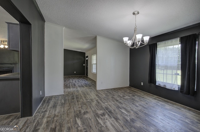 1525 Bailey Rd, Aragon, GA 30104 - empty room with a chandelier, dark wood-style floors, healthy amount of natural light, and a textured ceiling