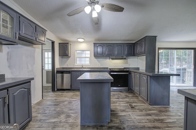 1525 Bailey Rd, Aragon, GA 30104 - kitchen with appliances with stainless steel finishes, a peninsula, a textured ceiling, dark wood-style floors, and a ceiling fan