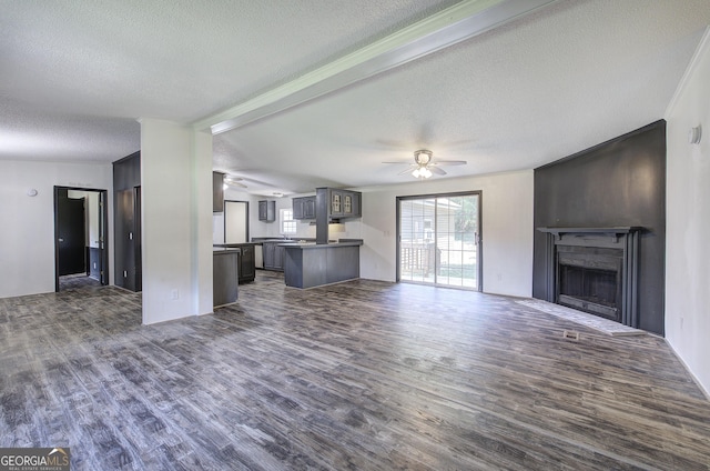 1525 Bailey Rd, Aragon, GA 30104 - unfurnished living room with a textured ceiling, a ceiling fan, dark wood-type flooring, and a fireplace