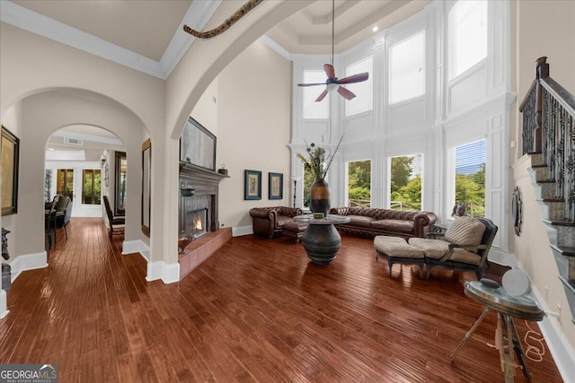 932 Shadowford Fls, Lithonia, GA 30058 - living room featuring a high ceiling, ceiling fan, ornamental molding, dark wood finished floors, and a tile fireplace
