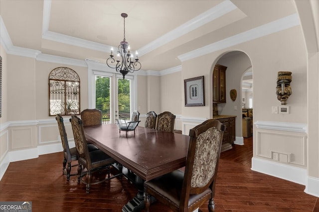932 Shadowford Fls, Lithonia, GA 30058 - dining room with a raised ceiling, arched walkways, dark wood-type flooring, a chandelier, and wainscoting