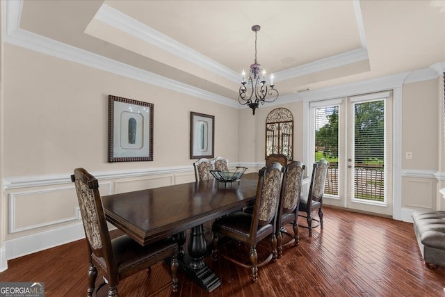 932 Shadowford Fls, Lithonia, GA 30058 - dining space featuring a raised ceiling, a chandelier, a decorative wall, crown molding, and a wainscoted wall