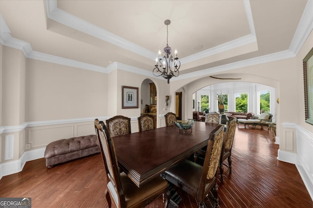 932 Shadowford Fls, Lithonia, GA 30058 - dining room featuring arched walkways, a raised ceiling, a chandelier, crown molding, and a wainscoted wall