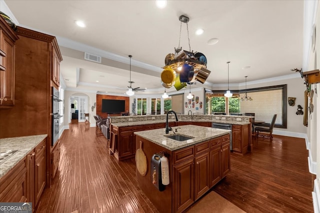 932 Shadowford Fls, Lithonia, GA 30058 - kitchen featuring a large island with sink, open floor plan, a ceiling fan, arched walkways, and brown cabinets