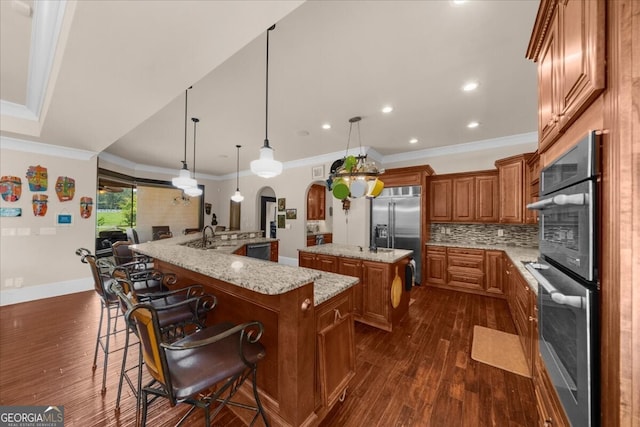 932 Shadowford Fls, Lithonia, GA 30058 - kitchen with appliances with stainless steel finishes, a large island, brown cabinets, dark wood-type flooring, and crown molding