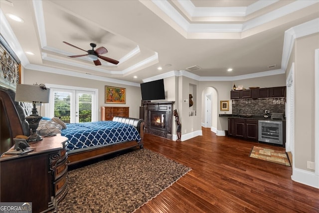 932 Shadowford Fls, Lithonia, GA 30058 - bedroom with a tray ceiling, wine cooler, arched walkways, ornamental molding, and dark wood-style floors