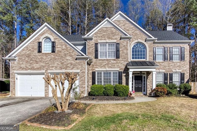 2516 Woolwich Ct, Acworth, GA 30101 - view of front of home with asphalt driveway, a front yard, a chimney, an attached garage, and brick siding