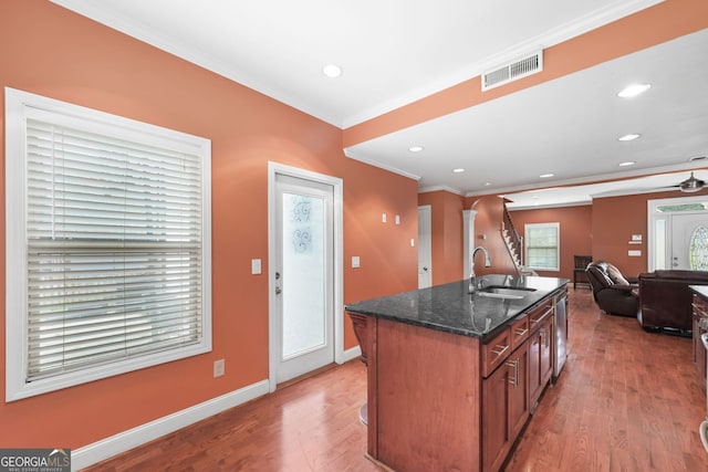 2670 Trotters Pointe Dr, Snellville, GA 30039 - kitchen with ornamental molding, light wood-style flooring, dark stone counters, an island with sink, and open floor plan