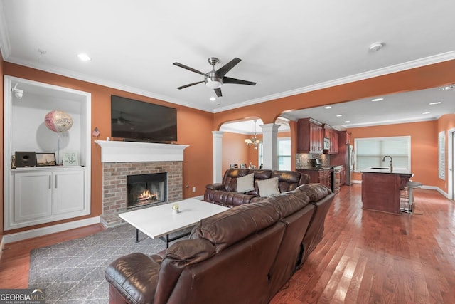 2670 Trotters Pointe Dr, Snellville, GA 30039 - living room featuring decorative columns, arched walkways, wood finished floors, a fireplace, and ceiling fan