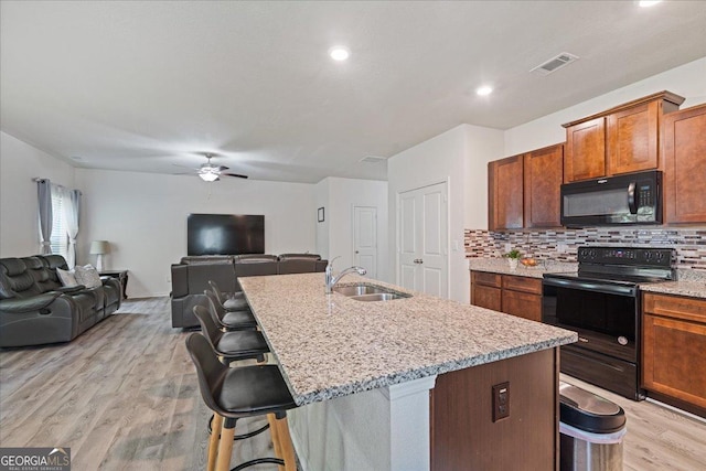 255 Morning Dr, Athens, GA 30606 - kitchen with black appliances, decorative backsplash, light wood-type flooring, a ceiling fan, and a kitchen island with sink