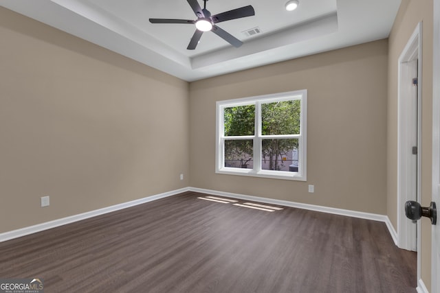 402 Power Plant Rd, Hogansville, GA 30230 - unfurnished room with a tray ceiling, dark wood-style flooring, and a ceiling fan