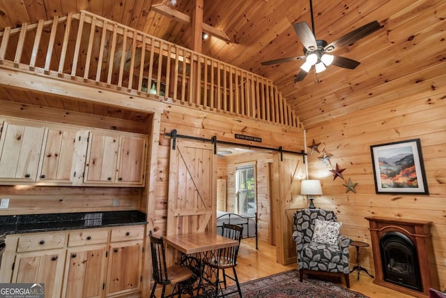 72 Bentley Cv, Murphy, NC 28960 - kitchen with a barn door, wooden ceiling, wooden walls, dark countertops, and high vaulted ceiling