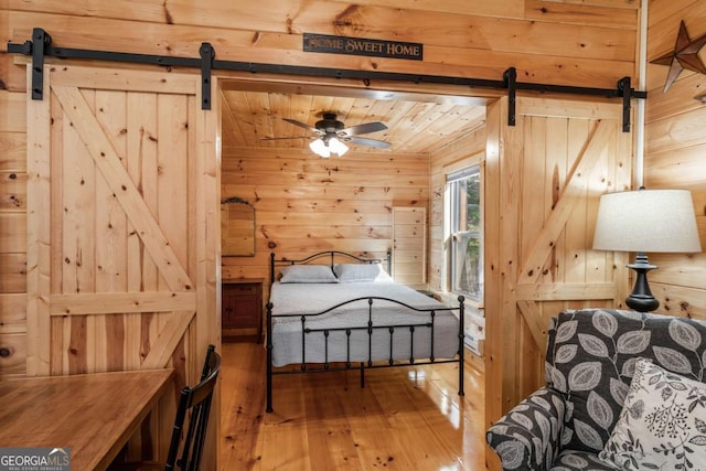 72 Bentley Cv, Murphy, NC 28960 - bedroom featuring a barn door, wooden walls, and wood-type flooring