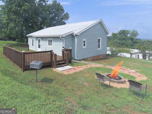 79 Hillside St, Nelson, GA 30151 - back of property featuring a fire pit, a wooden deck, a yard, and a metal roof