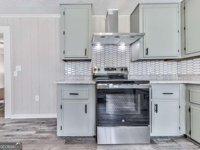 79 Hillside St, Nelson, GA 30151 - kitchen with electric stove, wall chimney range hood, light countertops, light wood-style floors, and a textured ceiling