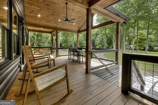 211 Rockhouse Rd, Cherry Log, GA 30522 - wooden deck featuring ceiling fan, outdoor dining area, and view of wooded area