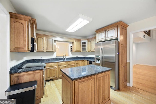 171 Loraine Forest Dr, Macon, GA 31210 - kitchen with stainless steel appliances, light wood finished floors, a kitchen island, dark stone counters, and glass insert cabinets
