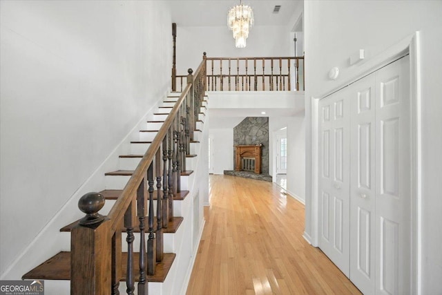 171 Loraine Forest Dr, Macon, GA 31210 - stairs featuring a high ceiling, wood finished floors, a chandelier, and a fireplace