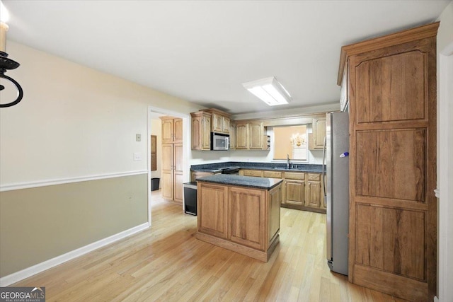 171 Loraine Forest Dr, Macon, GA 31210 - kitchen featuring appliances with stainless steel finishes, light wood finished floors, dark countertops, and a center island