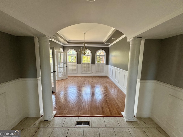 550 Masters Cir, Dublin, GA 31021 - unfurnished dining area with a raised ceiling, decorative columns, crown molding, arched walkways, and wainscoting