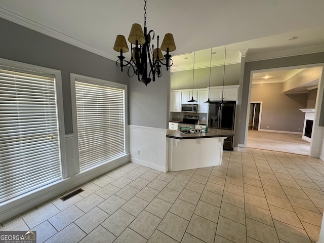 550 Masters Cir, Dublin, GA 31021 - kitchen featuring appliances with stainless steel finishes, crown molding, a peninsula, light tile patterned floors, and a chandelier