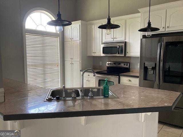 550 Masters Cir, Dublin, GA 31021 - kitchen with stainless steel appliances, white cabinets, pendant lighting, light tile patterned floors, and a breakfast bar