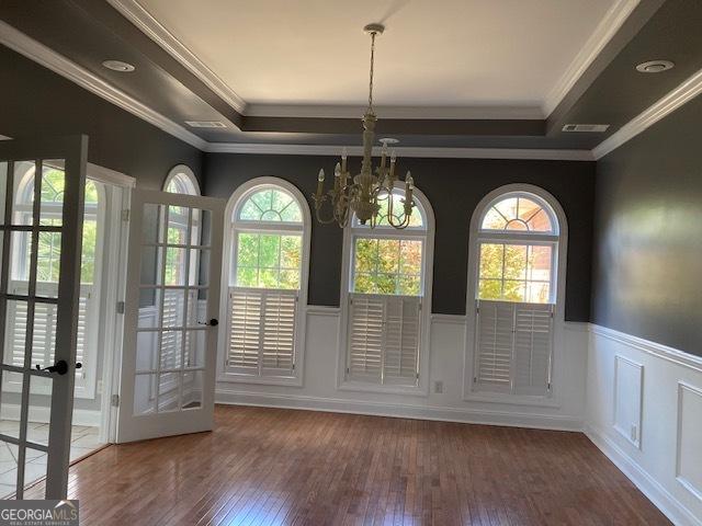 550 Masters Cir, Dublin, GA 31021 - doorway featuring a tray ceiling, hardwood / wood-style flooring, a chandelier, wainscoting, and ornamental molding